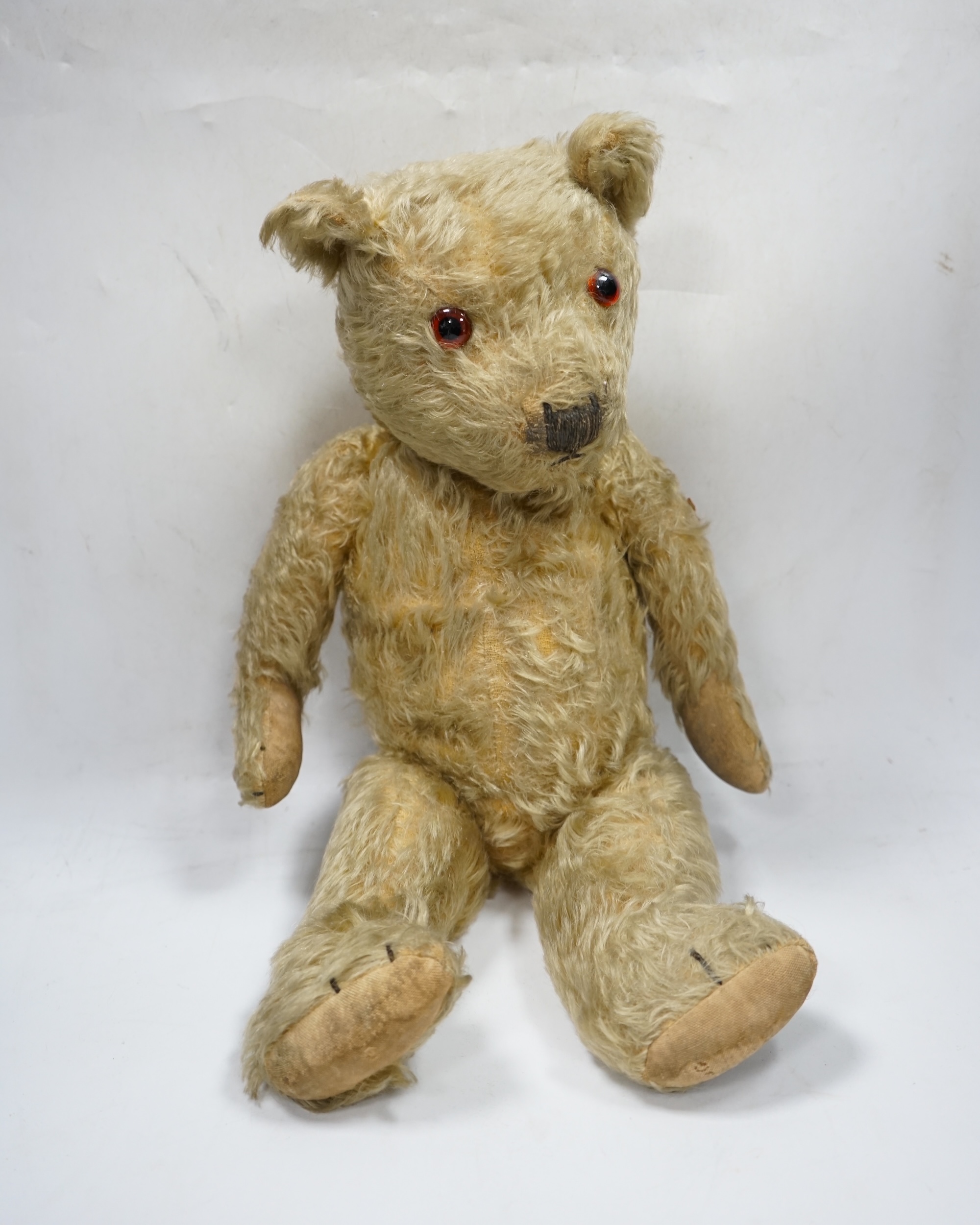 A 1930’s English Teddy bear, gold mohair plush and glass eyes, 49cm. Condition - fair
